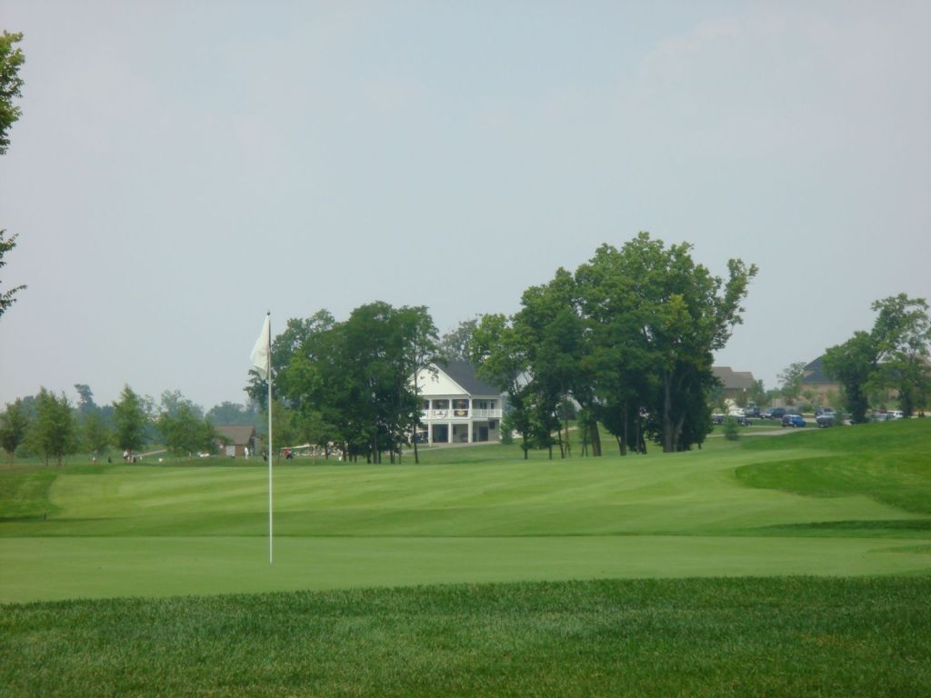 clubhouse behind a green with a white flag